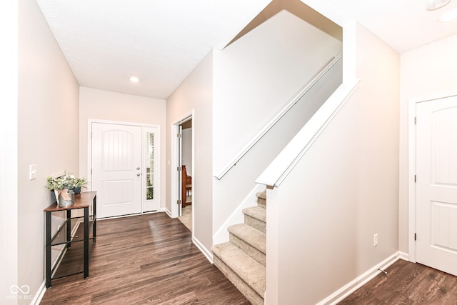 foyer entrance with stairway, baseboards, and dark wood-type flooring