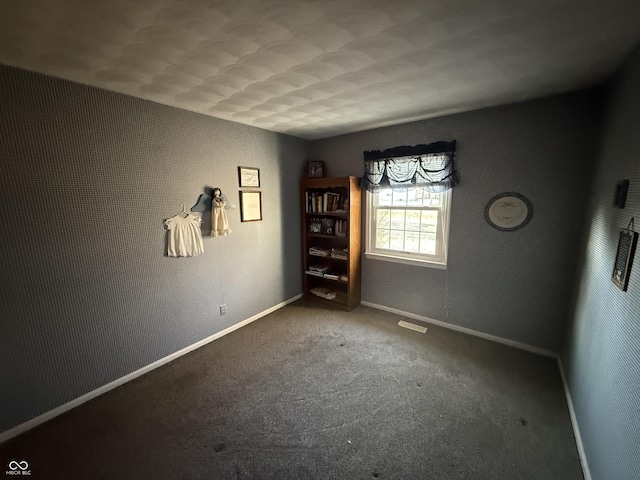 carpeted empty room featuring baseboards