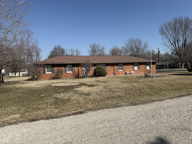 single story home with brick siding and a front yard