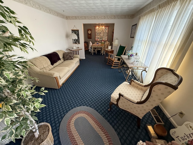 living area featuring dark carpet and baseboards