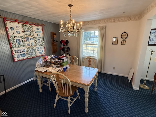 carpeted dining area with a chandelier and baseboards