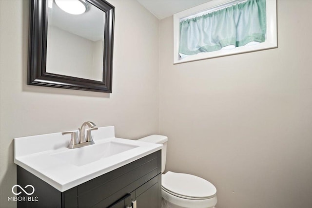 half bath featuring toilet and vanity