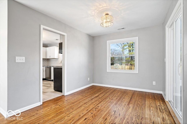 unfurnished room featuring visible vents, baseboards, and light wood-style flooring