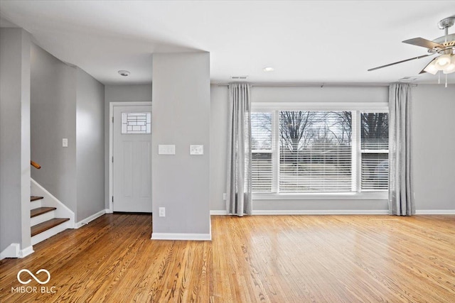 entrance foyer featuring stairway, wood finished floors, baseboards, and ceiling fan