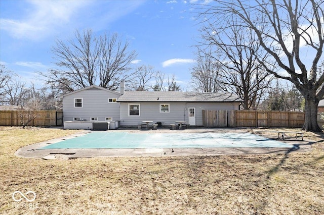 back of property with a fenced in pool, a chimney, a patio, and fence