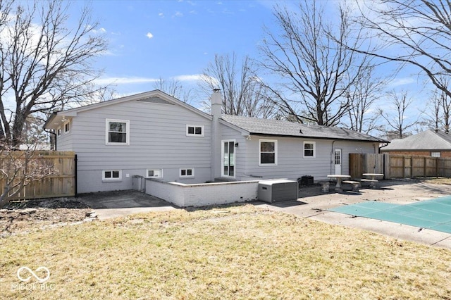 rear view of house with a patio, fence, a fenced in pool, a chimney, and a lawn