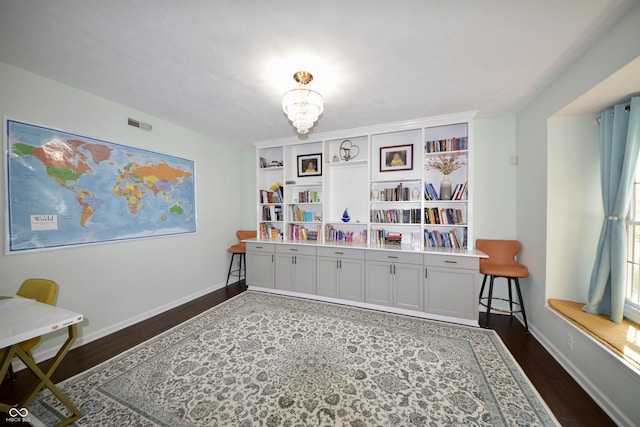 playroom featuring dark wood finished floors, a notable chandelier, visible vents, and baseboards