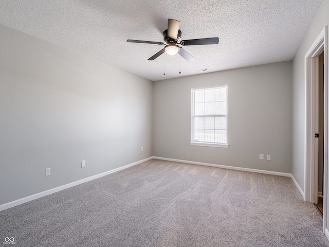 empty room featuring visible vents, ceiling fan, baseboards, carpet floors, and a textured ceiling