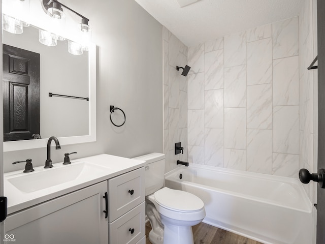 bathroom with vanity, toilet, wood finished floors, and shower / washtub combination