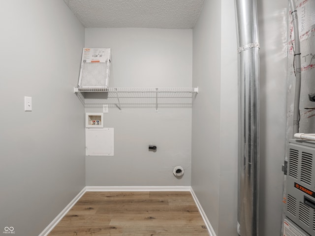 laundry area featuring hookup for a washing machine, wood finished floors, baseboards, and a textured ceiling