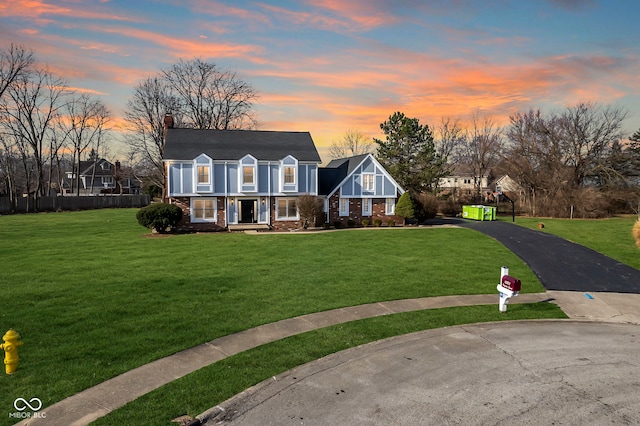 view of front of home featuring a front lawn, brick siding, and driveway