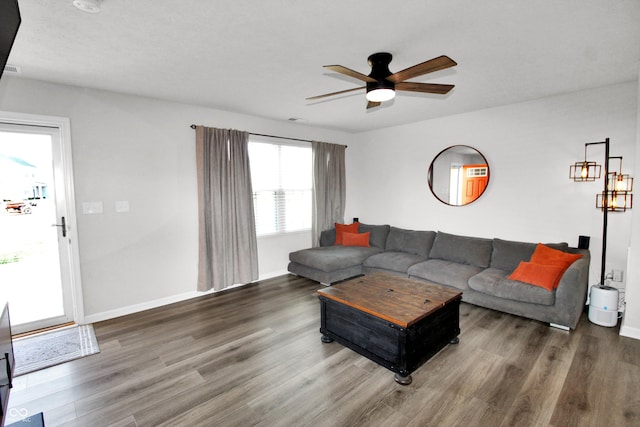 living area featuring baseboards, wood finished floors, and a ceiling fan