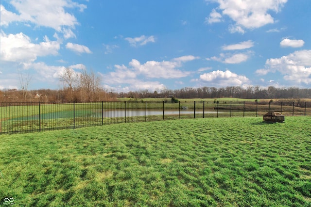 view of yard featuring a water view, a rural view, and fence