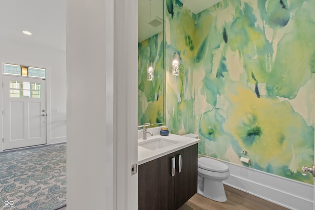 bathroom with recessed lighting, toilet, vanity, and wood finished floors