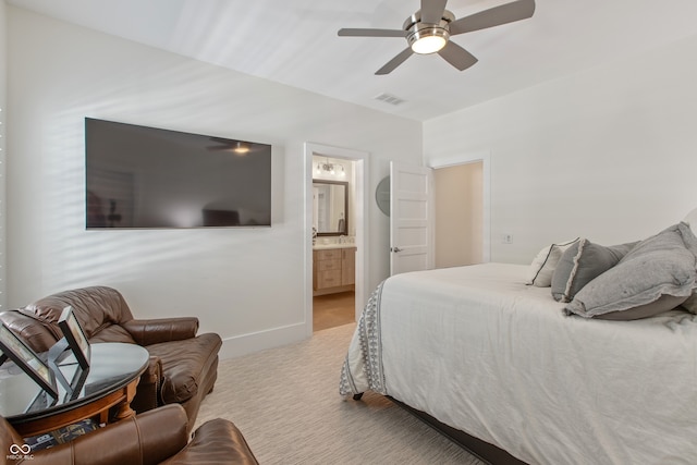 carpeted bedroom with ensuite bath, baseboards, visible vents, and ceiling fan