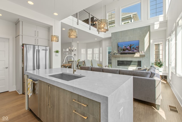 kitchen featuring visible vents, a sink, open floor plan, dishwasher, and a chandelier