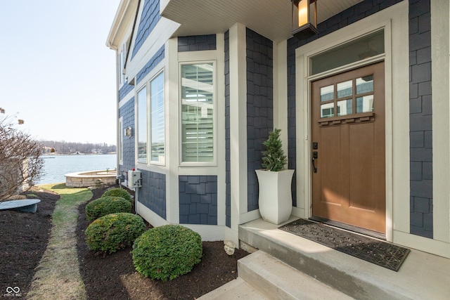 entrance to property featuring a porch and a water view