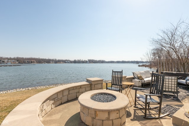 view of patio / terrace featuring an outdoor fire pit and a water view