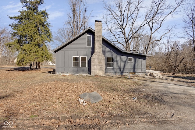 view of side of property featuring board and batten siding and a chimney