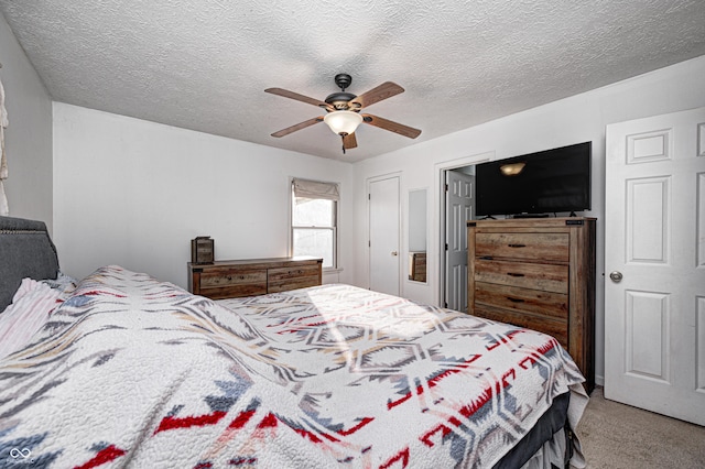 bedroom featuring a ceiling fan, carpet flooring, and a textured ceiling