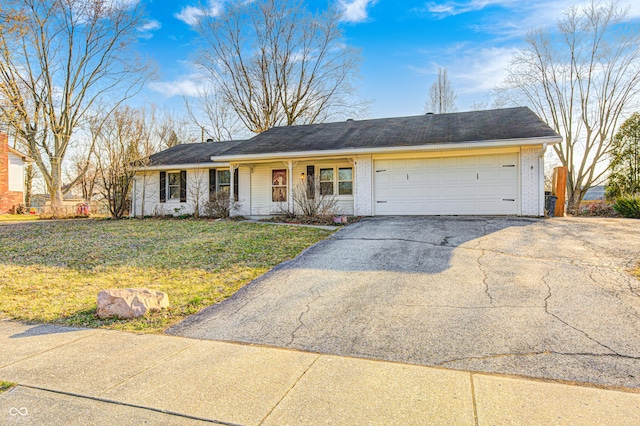 single story home featuring a front lawn, a garage, brick siding, and driveway