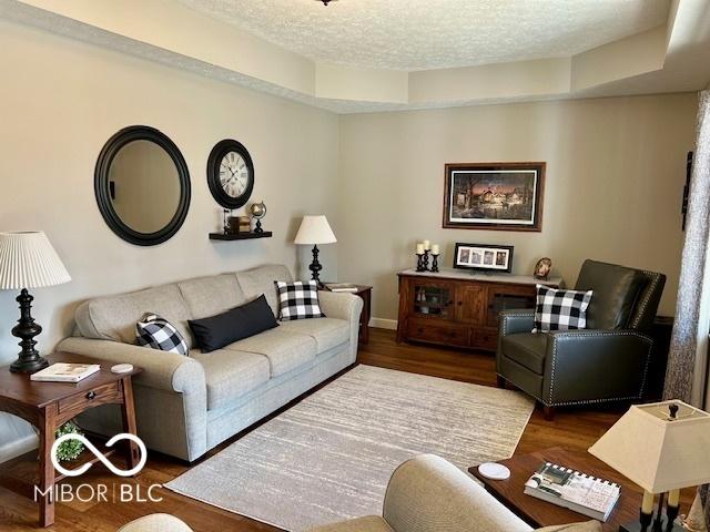 living room featuring a textured ceiling and wood finished floors