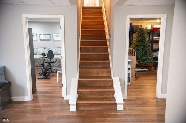 stairway with wood finished floors and baseboards