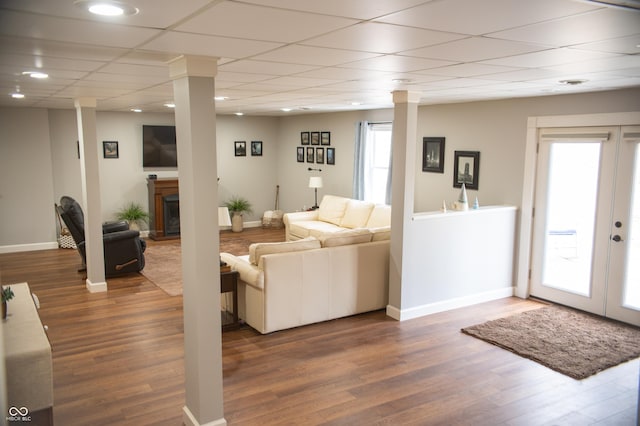 living area with plenty of natural light, wood finished floors, and decorative columns