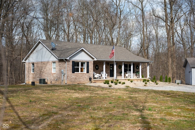 ranch-style house with a porch, central air condition unit, brick siding, and a front yard