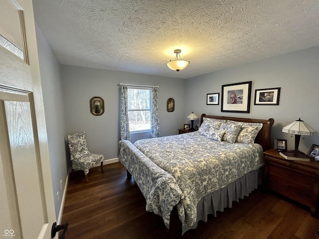 bedroom featuring baseboards, a textured ceiling, and dark wood-style floors