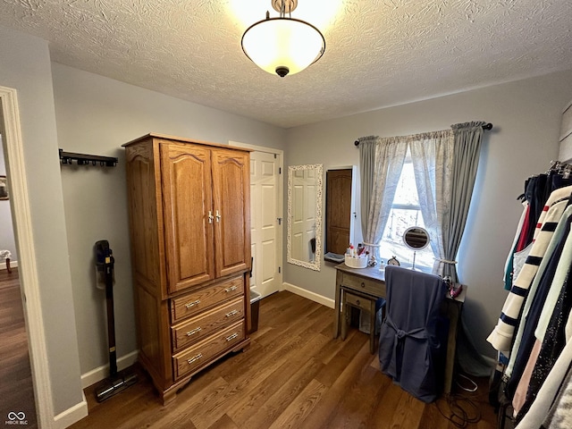 home office featuring dark wood-type flooring, baseboards, and a textured ceiling