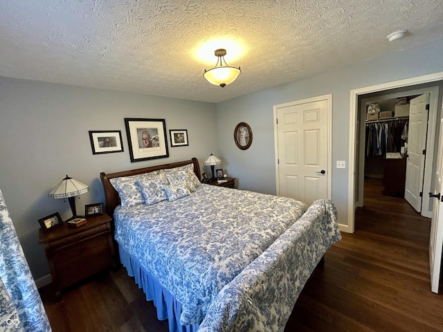 bedroom featuring a textured ceiling, baseboards, and wood finished floors