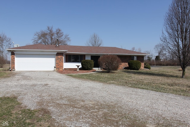 ranch-style house with brick siding, driveway, an attached garage, and a front lawn