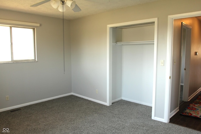 unfurnished bedroom featuring a closet, baseboards, visible vents, and dark carpet