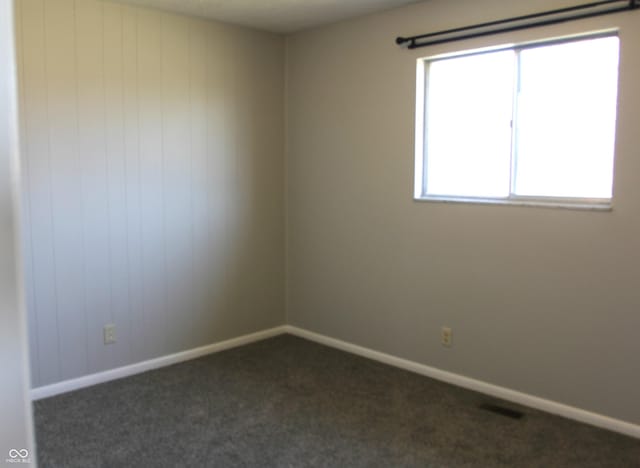 empty room with visible vents, baseboards, and carpet floors