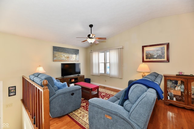 living room with baseboards, wood finished floors, a ceiling fan, and vaulted ceiling