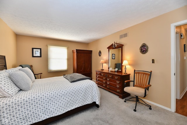 carpeted bedroom with visible vents, a textured ceiling, and baseboards