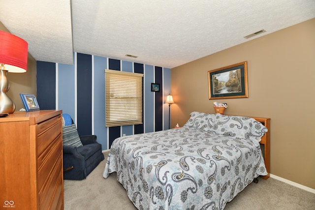 bedroom with a textured ceiling, light colored carpet, visible vents, and baseboards