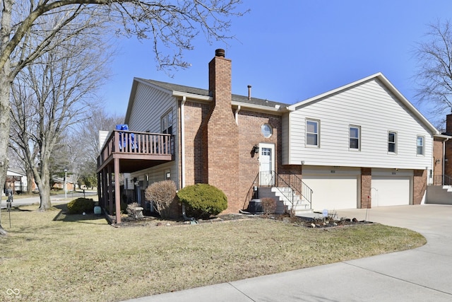 view of side of property featuring driveway, a yard, a garage, brick siding, and a chimney