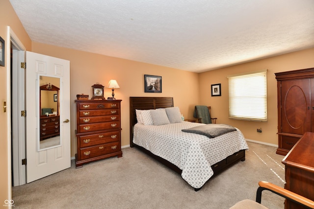 bedroom featuring a textured ceiling, baseboards, and light carpet