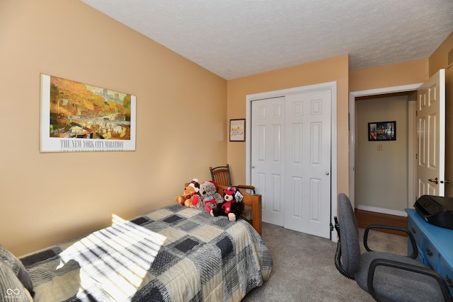 carpeted bedroom with a closet and a textured ceiling