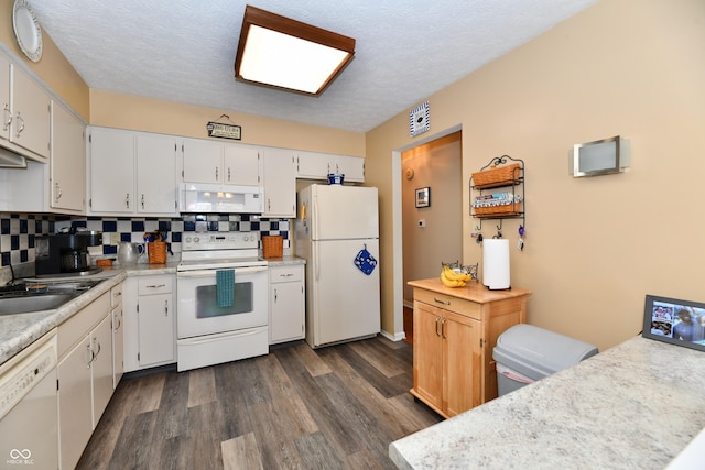 kitchen with white appliances, tasteful backsplash, dark wood finished floors, and light countertops