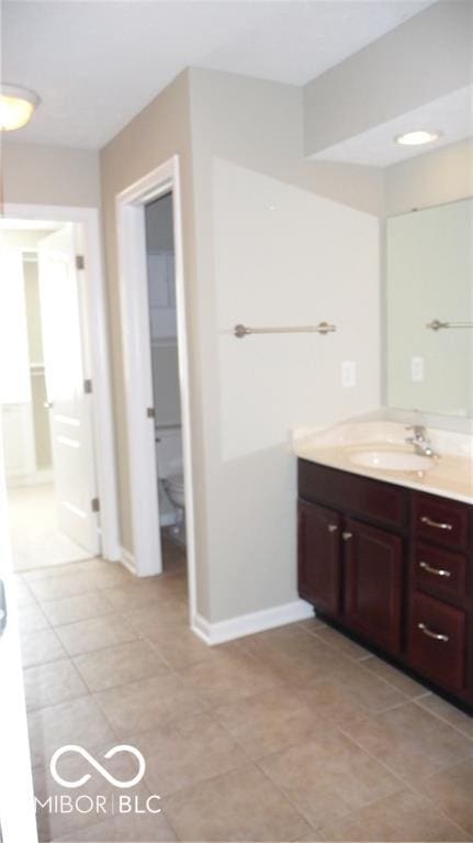 bathroom featuring tile patterned flooring, vanity, and baseboards