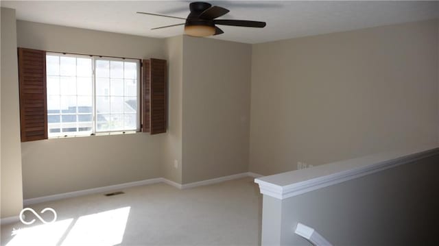 unfurnished room with visible vents, carpet, baseboards, and ceiling fan