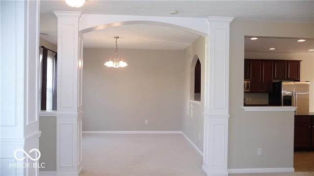 interior space with an inviting chandelier, recessed lighting, baseboards, and arched walkways