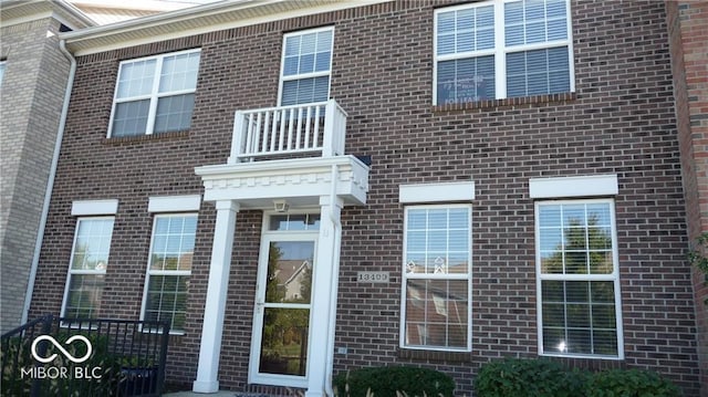 view of front of property featuring a balcony and brick siding