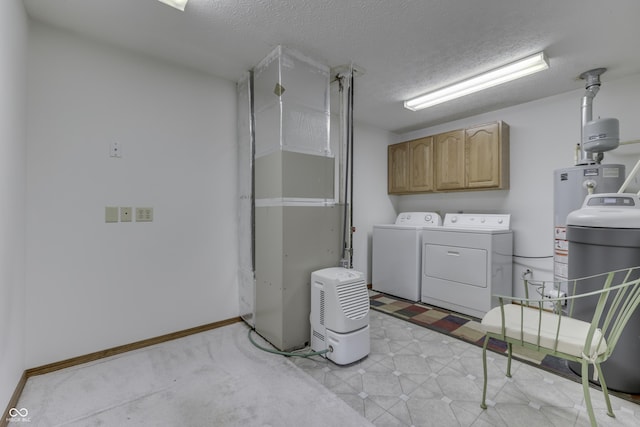 washroom featuring light floors, baseboards, separate washer and dryer, cabinet space, and a textured ceiling