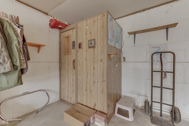 bathroom featuring wood walls and unfinished concrete floors