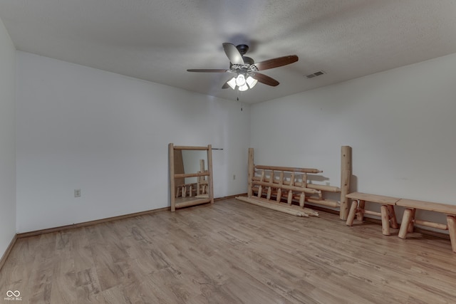 unfurnished bedroom with a ceiling fan, baseboards, wood finished floors, visible vents, and a textured ceiling