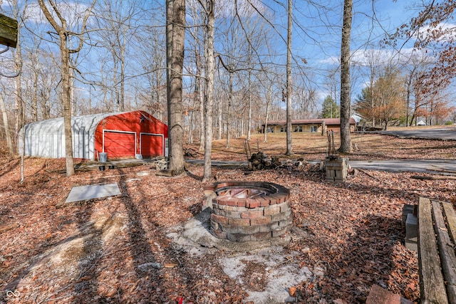 view of yard with an outdoor structure and a fire pit